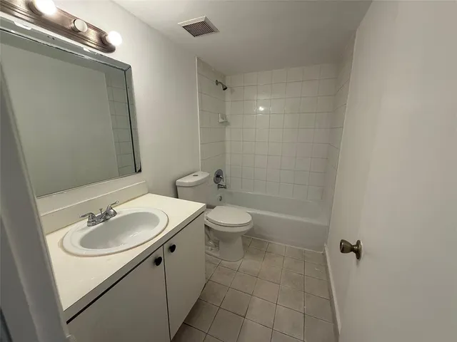 a white toilet and shower sitting next to a bathroom sink