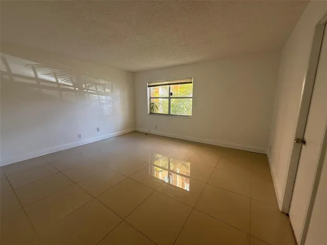 a view of an empty room with closet and a window