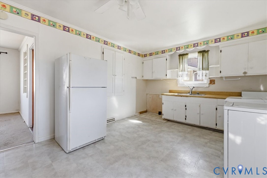 524 Clay Street Wakefield, VA 23888 - Photo 9 of 20 a kitchen with white cabinets and white appliances