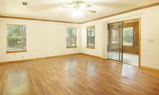 a view of an empty room with wooden floor