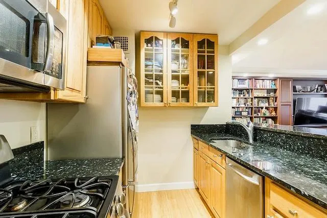 a kitchen with granite countertop a sink and a stove next to a window