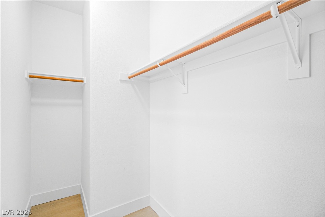 2182 Trivero Street Henderson, NV 89044 - Photo 24 of 50 A spacious walk-in closet features built-in wooden hanging rods and clean wood flooring.