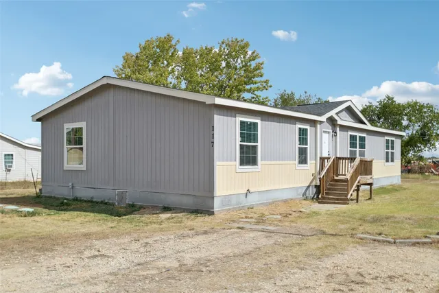 a backyard of a house with table and chairs