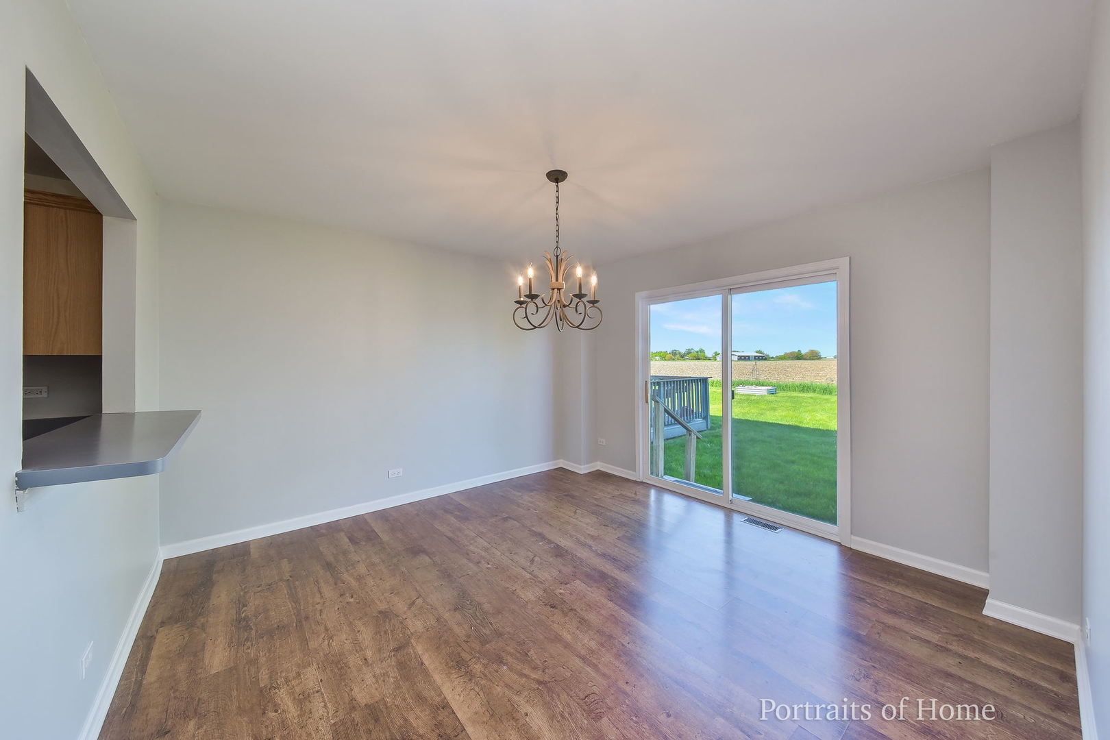 235 Rollin Road, Unit C Somonauk, IL 60552 - Photo 5 of 20 a view of an empty room with a window and wooden floor