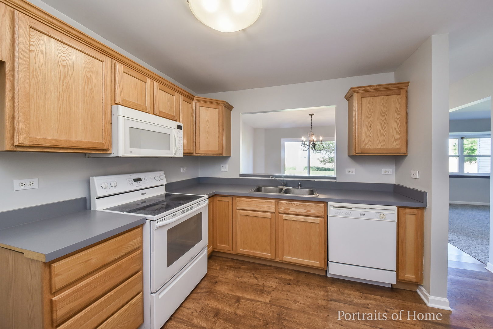 235 Rollin Road, Unit C Somonauk, IL 60552 - Photo 6 of 20 a kitchen with stainless steel appliances granite countertop a stove a sink and a microwave
