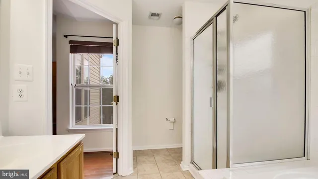a bathroom with a glass shower door and a sink