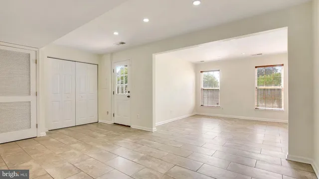 an empty room with windows and closet