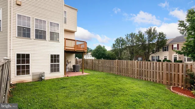 a view of a house with a yard and a large tree front of house