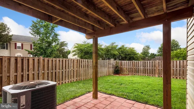 a view of a backyard with a swing chair and wooden fence