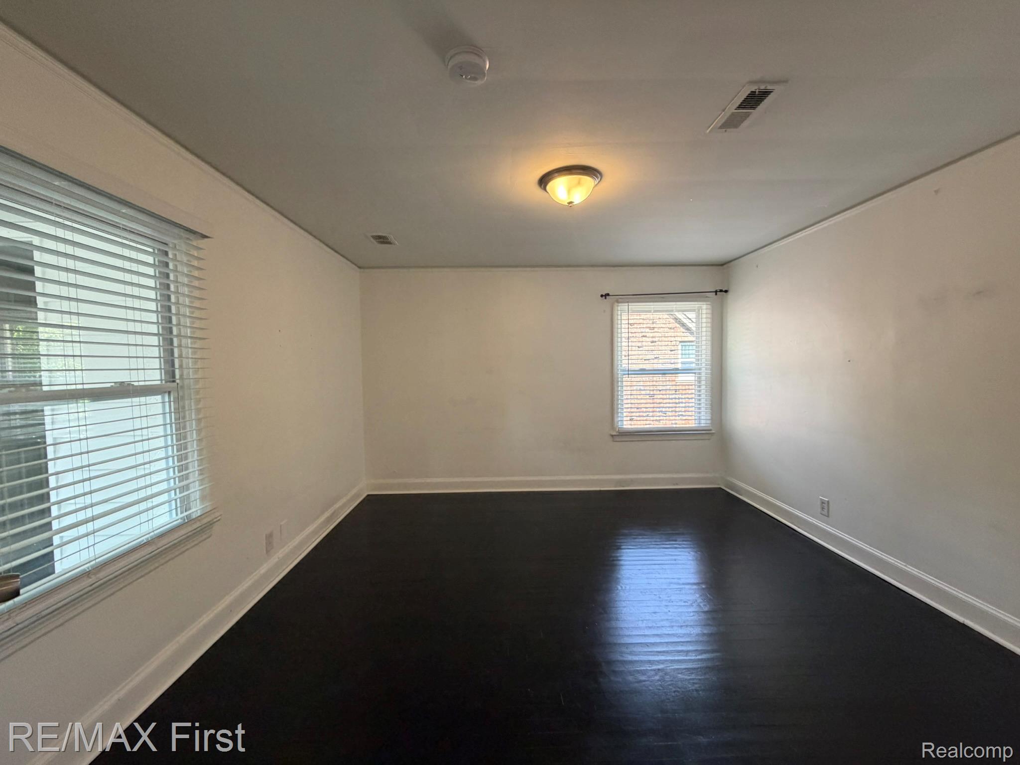 1349 Devonshire Road Grosse Pointe, MI 48230 - Photo 21 of 31 Dark wood-finish flooring, white walls, and two window openings with blinds