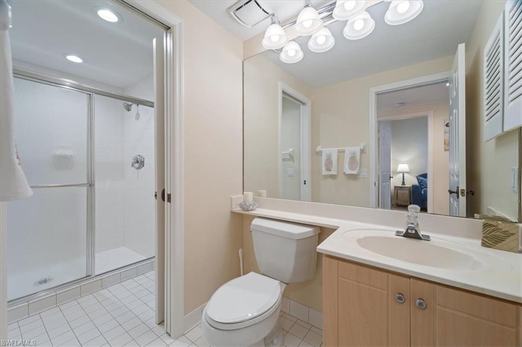 6549 Marissa Loop, Unit 15 Naples, FL 34108 - Photo 11 of 24 a bathroom with a toilet a sink a mirror and a shower