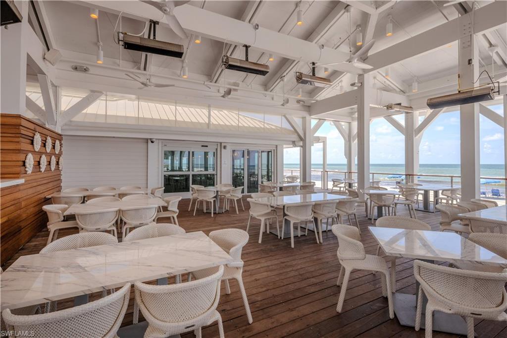 6549 Marissa Loop, Unit 15 Naples, FL 34108 - Photo 21 of 24 a room with lots of furniture a large window and chandelier