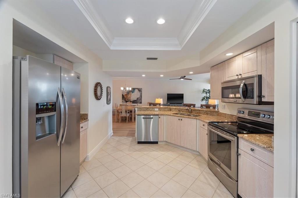 6549 Marissa Loop, Unit 15 Naples, FL 34108 - Photo 6 of 24 a kitchen with a sink stainless steel appliances and cabinets