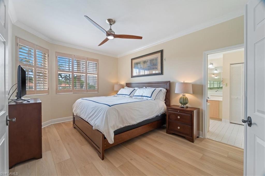 6549 Marissa Loop, Unit 15 Naples, FL 34108 - Photo 8 of 24 a spacious bedroom with a bed and a flat tv screen on dresser
