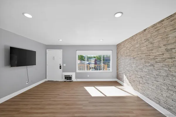 a view of empty room with wooden floor and windows