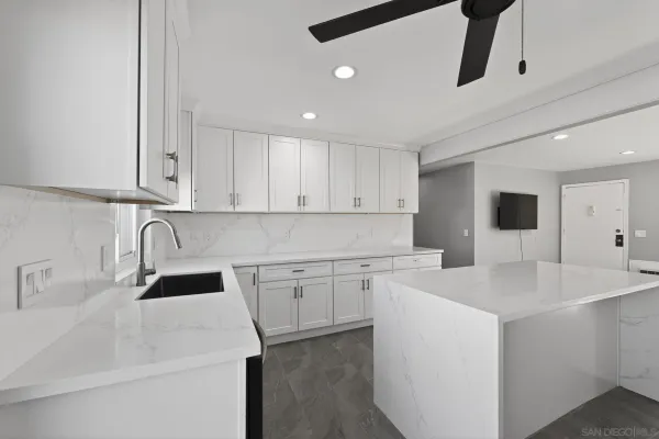 a kitchen with sink a microwave and cabinets