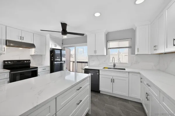 a kitchen with white cabinets and appliances