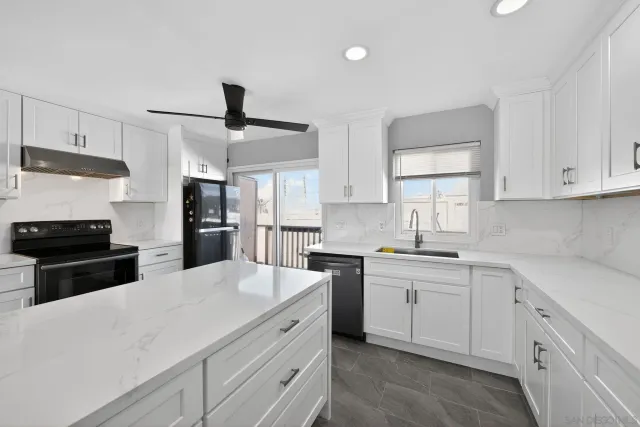 a kitchen with white cabinets and appliances