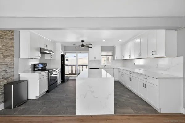 a large kitchen with cabinets wooden floor and stainless steel appliances