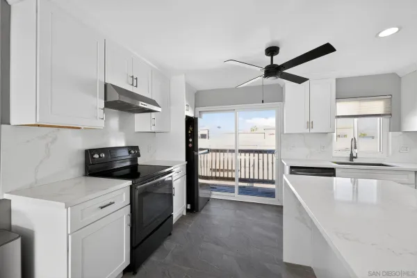 a kitchen with stainless steel appliances granite countertop a sink and a stove