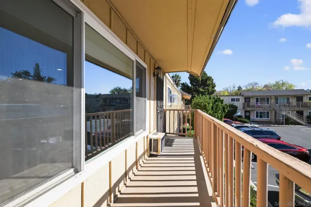 a view of a balcony with wooden floor and iron stairs
