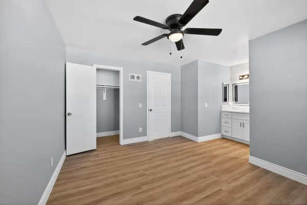 a view of a big room with wooden floor and a ceiling fan