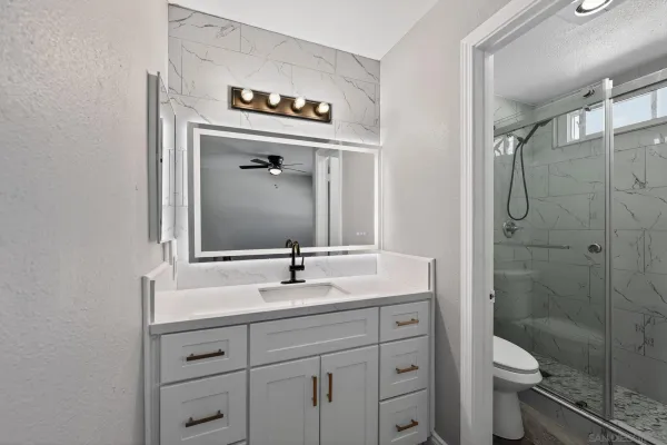 a bathroom with a toilet sink shower and mirror