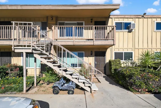 a view of a house with a small deck and furniture