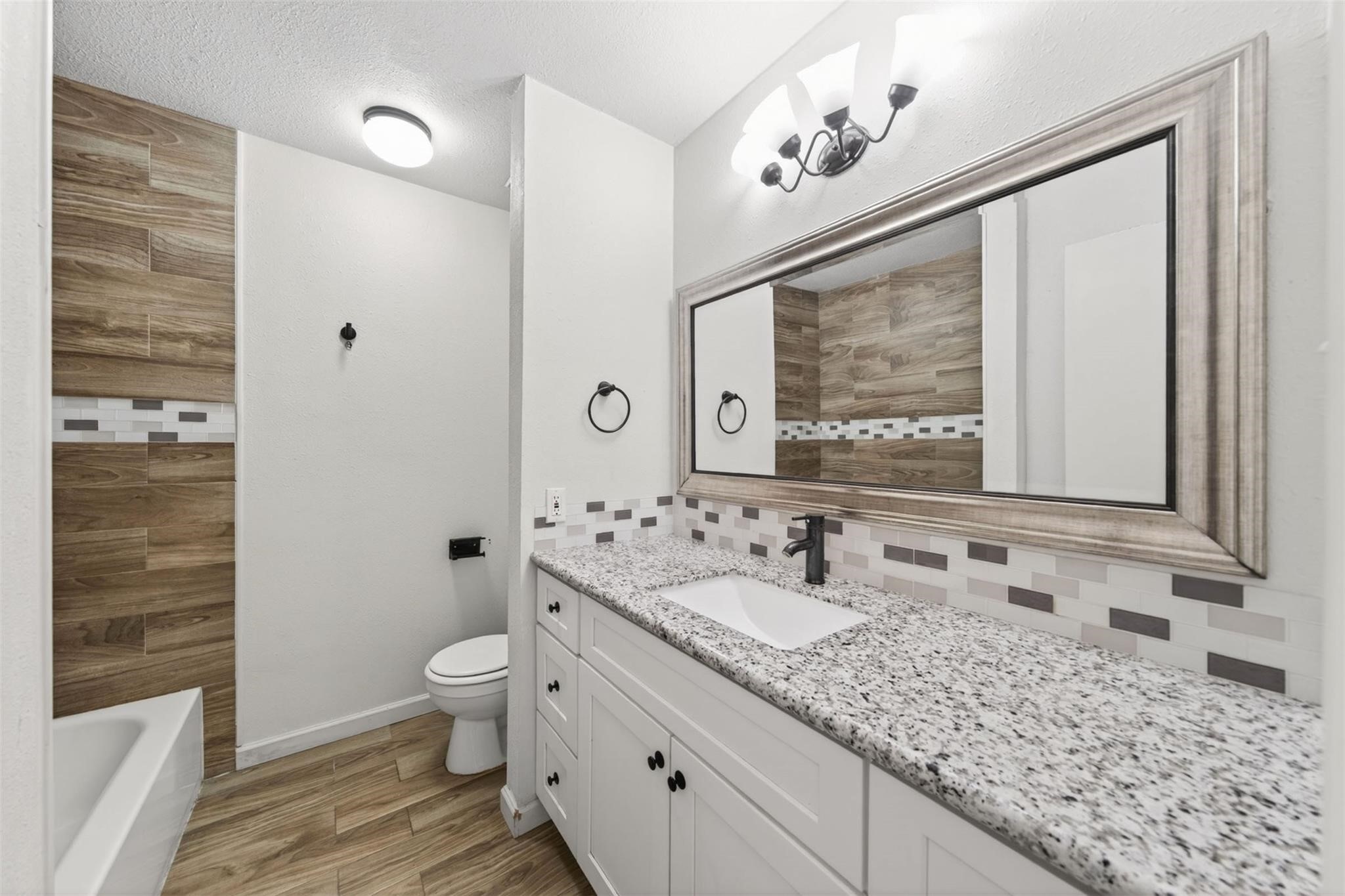 17002 Dew Drop Lane Houston, TX 77095 - Photo 18 of 24 a bathroom with a granite countertop sink a toilet a mirror and shower