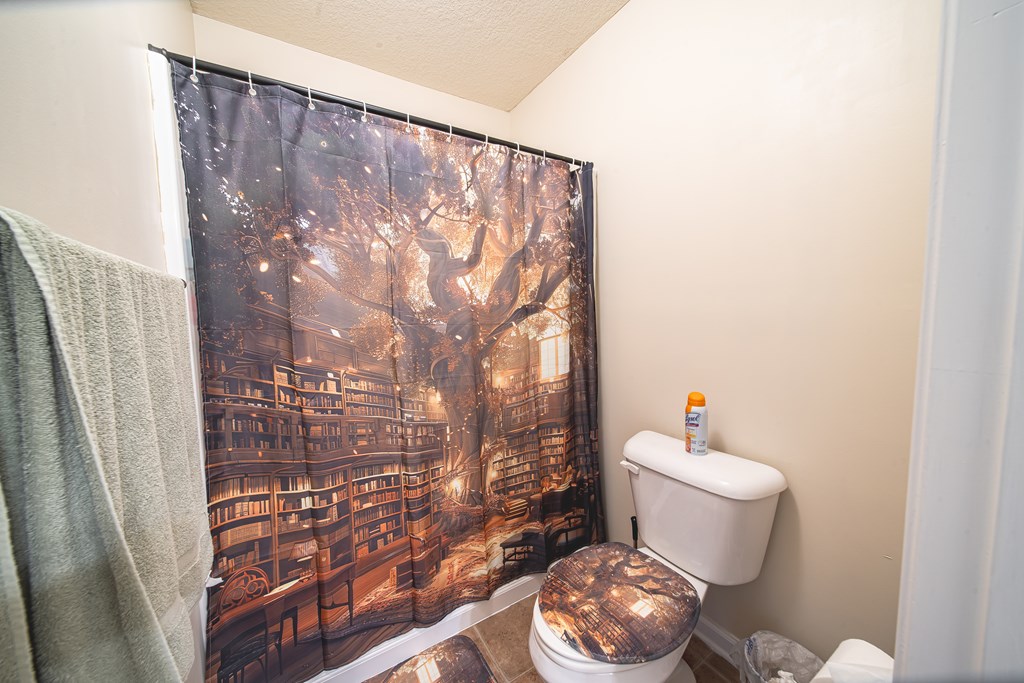 305 Owens Road Fort Mitchell, AL 36856 - Photo 28 of 44 a bathroom with a toilet and a shower curtain