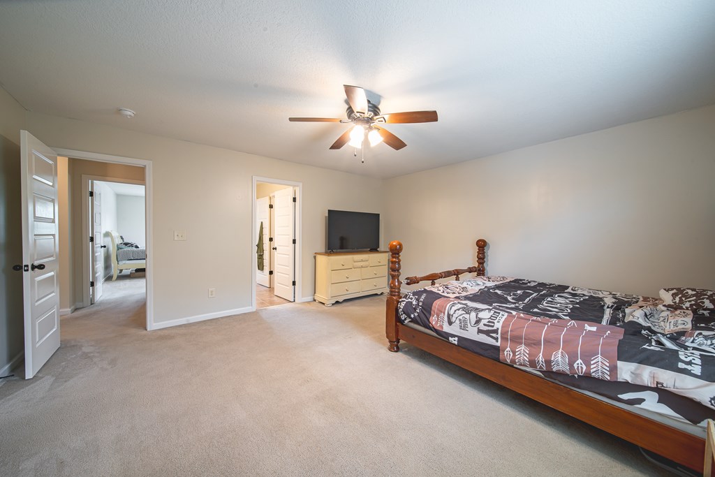 305 Owens Road Fort Mitchell, AL 36856 - Photo 31 of 44 a spacious bedroom with a bed and a chandelier