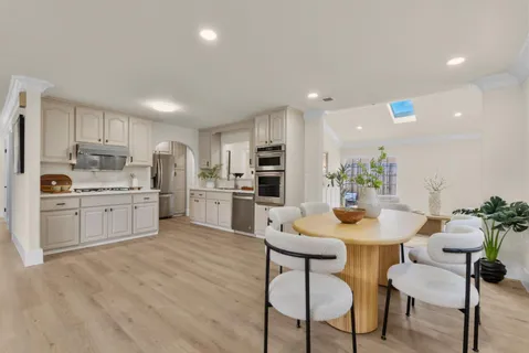a kitchen with a sink white cabinets and stainless steel appliances