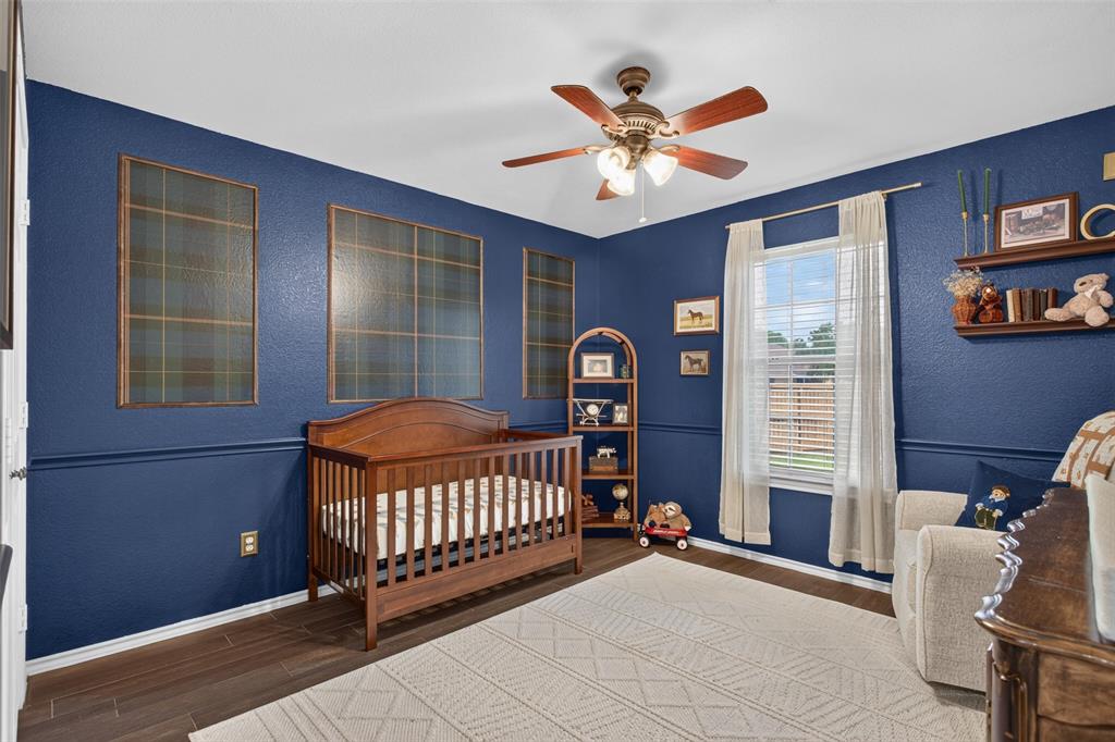 100 Radecke Road Krum, TX 76249 - Photo 21 of 29 Room with deep blue walls and wood-finish flooring