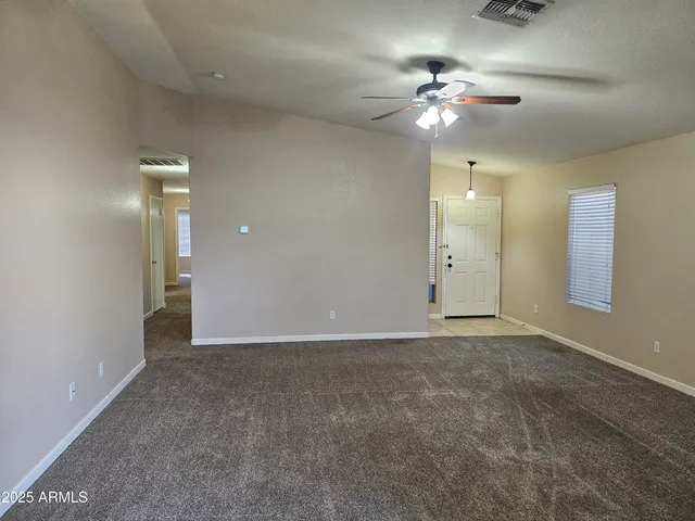 a view of an empty room with a chandelier fan