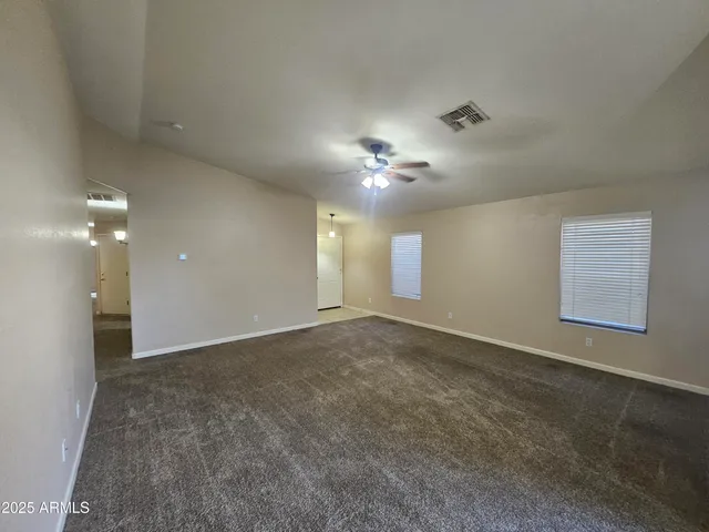 a view of an empty room with a chandelier fan