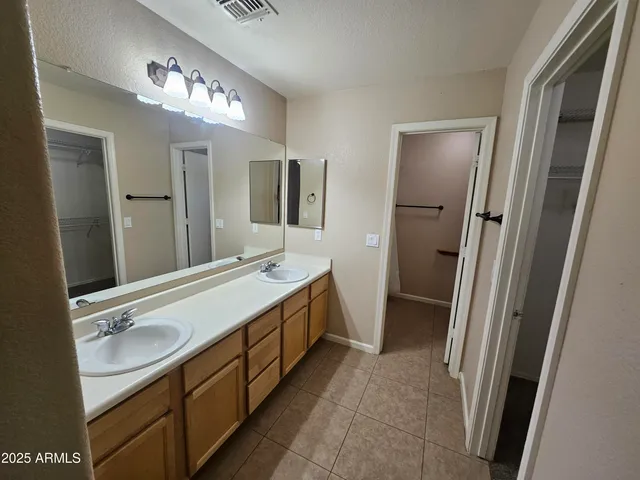 a bathroom with a double vanity sink and mirror with shower