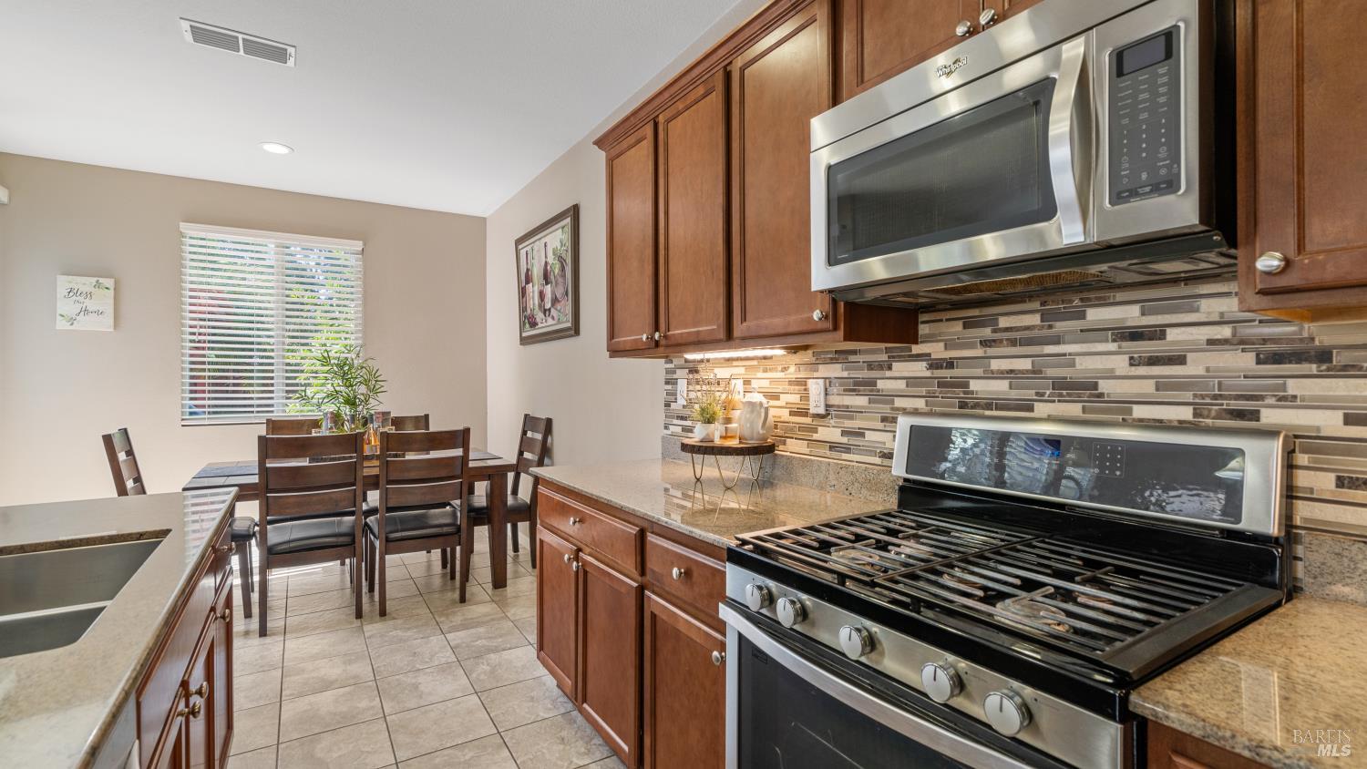 524 Chaparral Loop Vacaville, CA 95688 - Photo 15 of 43 a kitchen with a stove a microwave and wooden cabinets