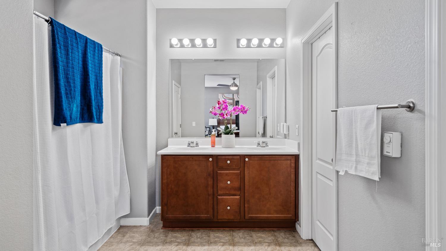 524 Chaparral Loop Vacaville, CA 95688 - Photo 26 of 43 a view of bathroom with a sink a mirror and a shower
