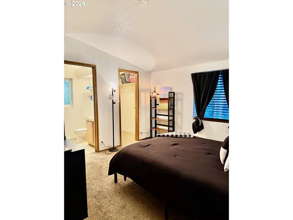 a bedroom with a bed and a painting on the wall