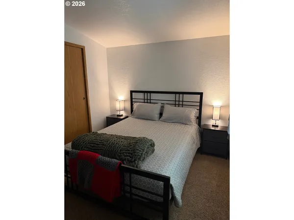 a bedroom with a bed and a night stand