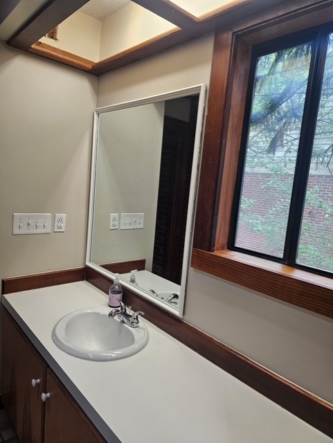 114 Houston Street Clemson, SC 29631 - Photo 13 of 19 Rich wood trim frames the window and ceiling panels above a clean white vanity.