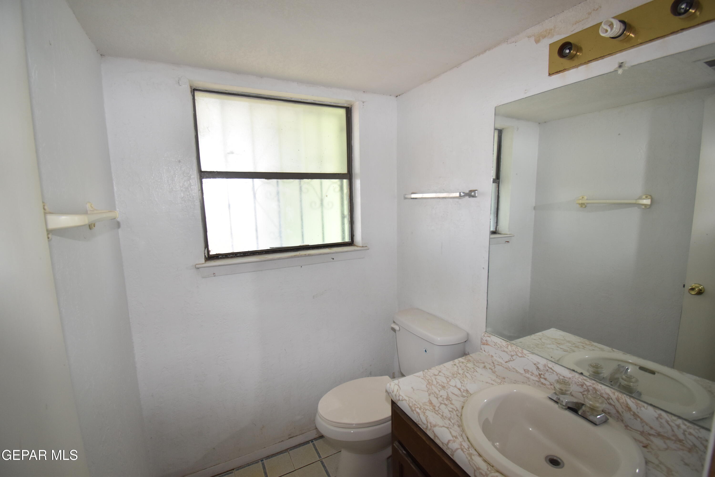 182 Prado Road El Paso, TX 79907 - Photo 13 of 19 a bathroom with a granite countertop toilet a sink and a mirror