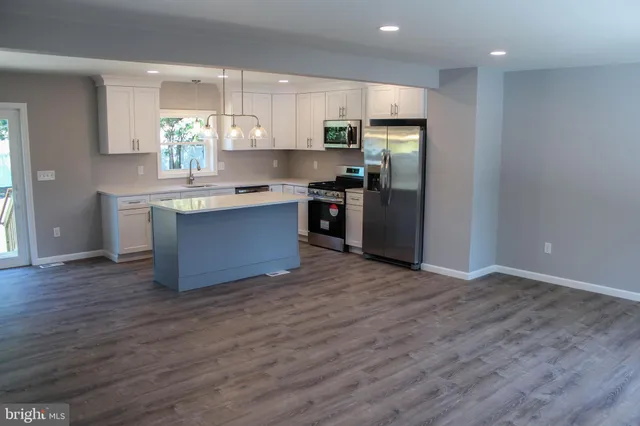 a kitchen with stainless steel appliances granite countertop a refrigerator and a stove top oven