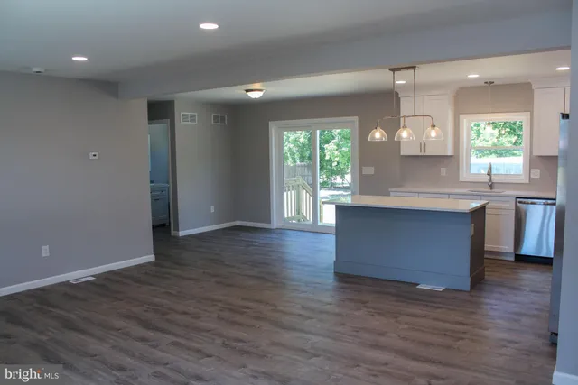 a kitchen with granite countertop wooden floors and wide window