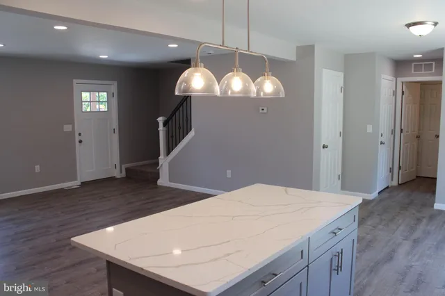 a kitchen with stainless steel appliances granite countertop a kitchen island a stove and a wooden floors