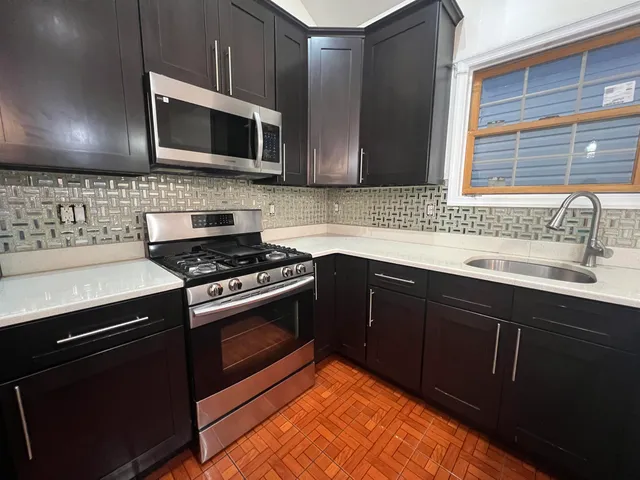 a kitchen with stainless steel appliances wooden cabinets and a sink stove