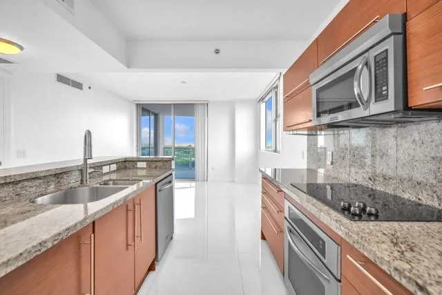 a kitchen with granite countertop a sink and cabinets
