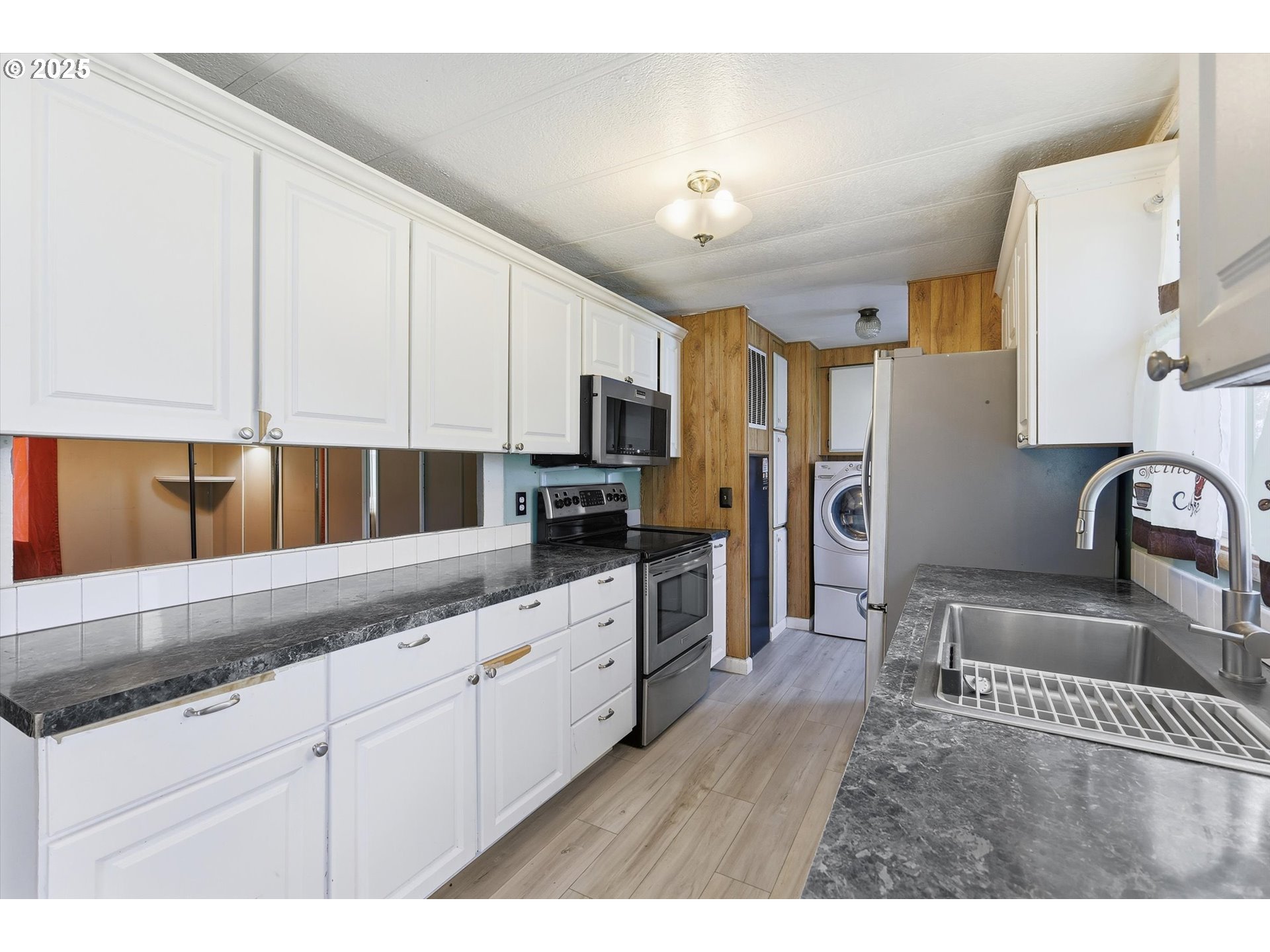 23200 Northeast Sandy Boulevard, Unit 77 Troutdale, OR 97060 - Photo 16 of 43 a kitchen with stainless steel appliances granite countertop a sink dishwasher stove and refrigerator with wooden floor