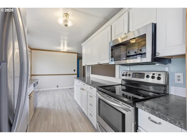 a kitchen with stainless steel appliances a stove microwave and sink