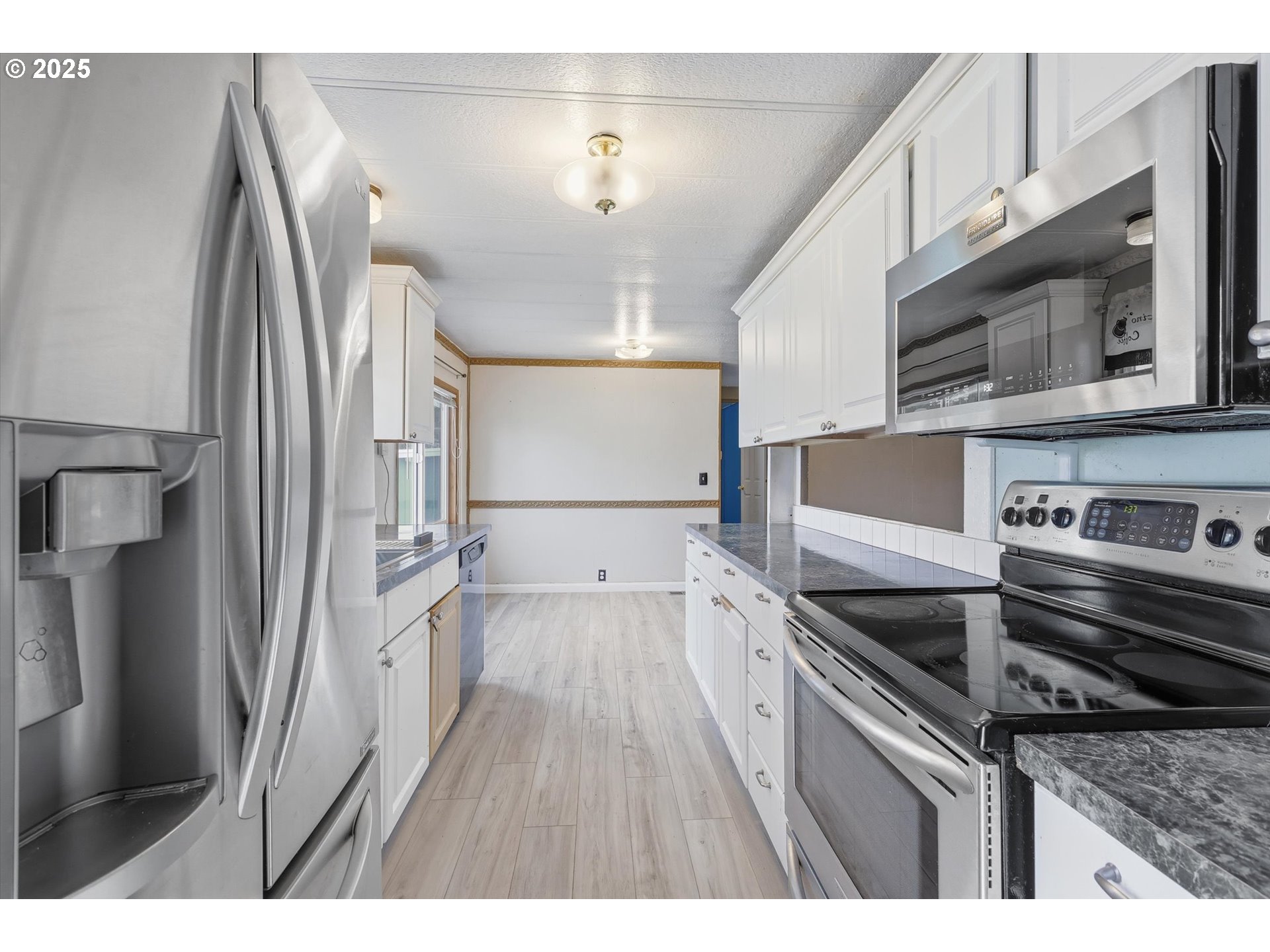 23200 Northeast Sandy Boulevard, Unit 77 Troutdale, OR 97060 - Photo 20 of 43 a kitchen with stainless steel appliances and wooden cabinets